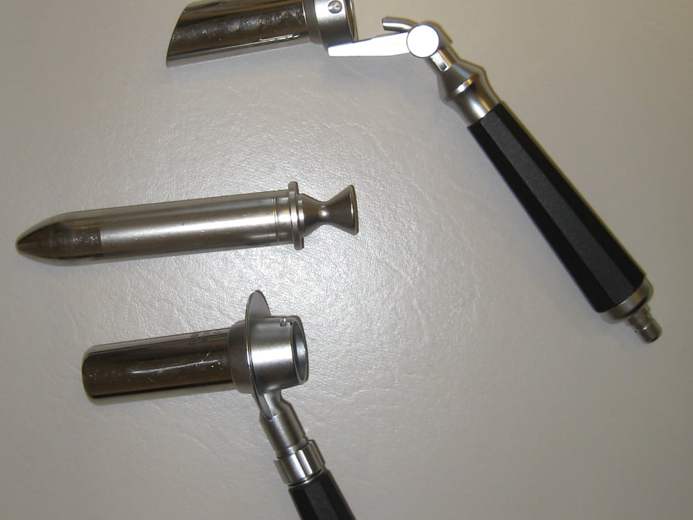 Used rigid endoscopy sheaths and obturators with insulated handles, laid out as-is, showing normal wear from prior clinical use