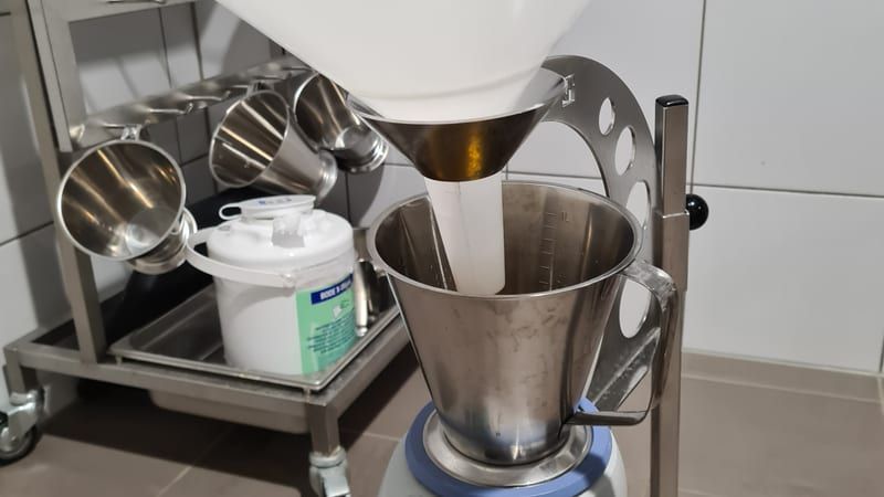 A uroflowmeter — urodynamics diagnostic equipment: a voiding funnel feeding a gravimetric flow-measuring unit on a wheeled cart, used to measure urine flow rate