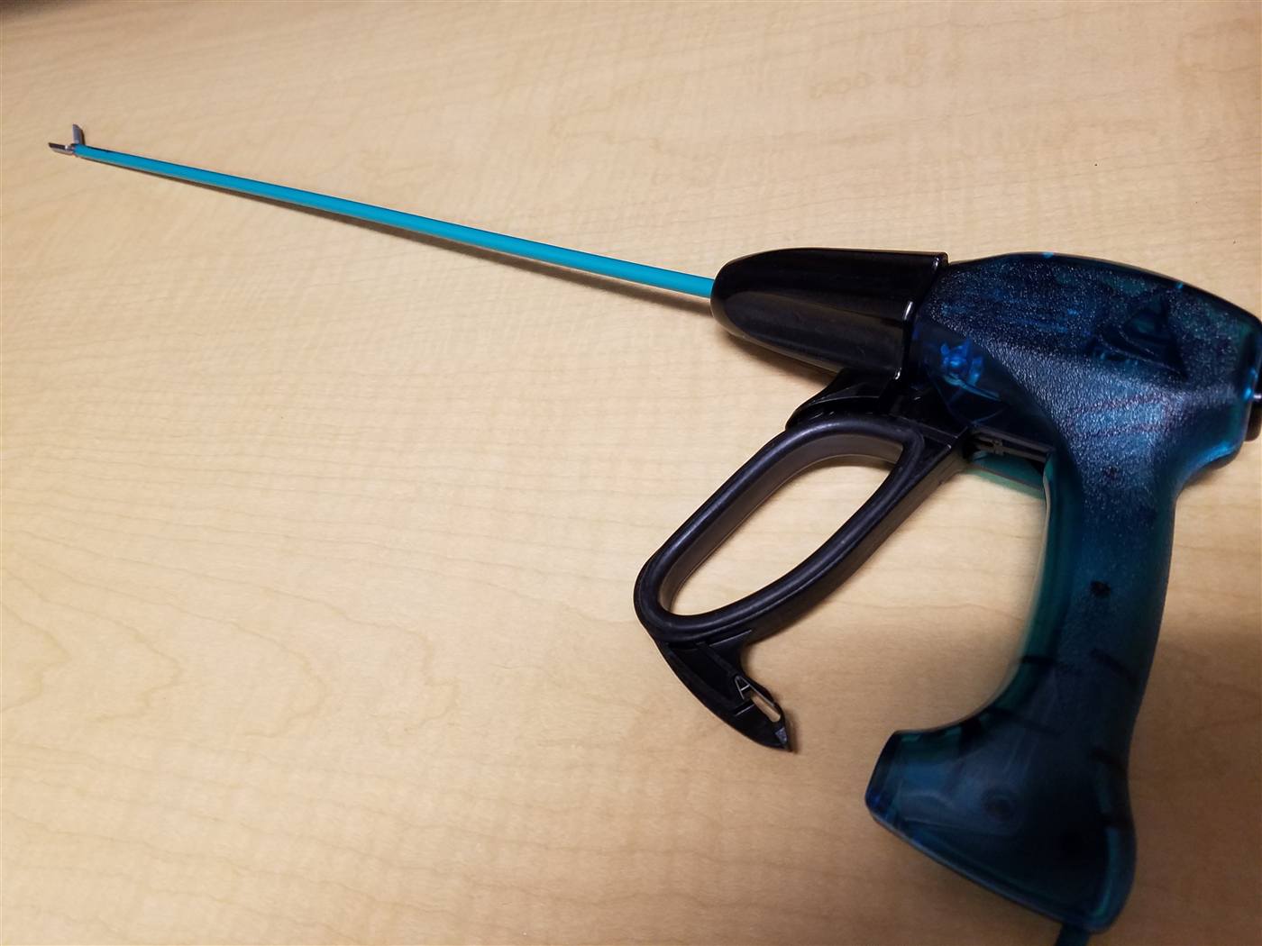 A laparoscopic vessel-sealing energy handpiece with a pistol-grip trigger handle, elongated shaft, and end-effector jaws