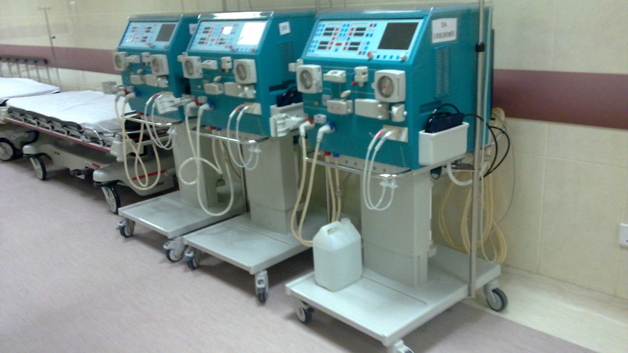 Surplus medical equipment — dialysis machines and a hospital bed — staged together for resale and removal.