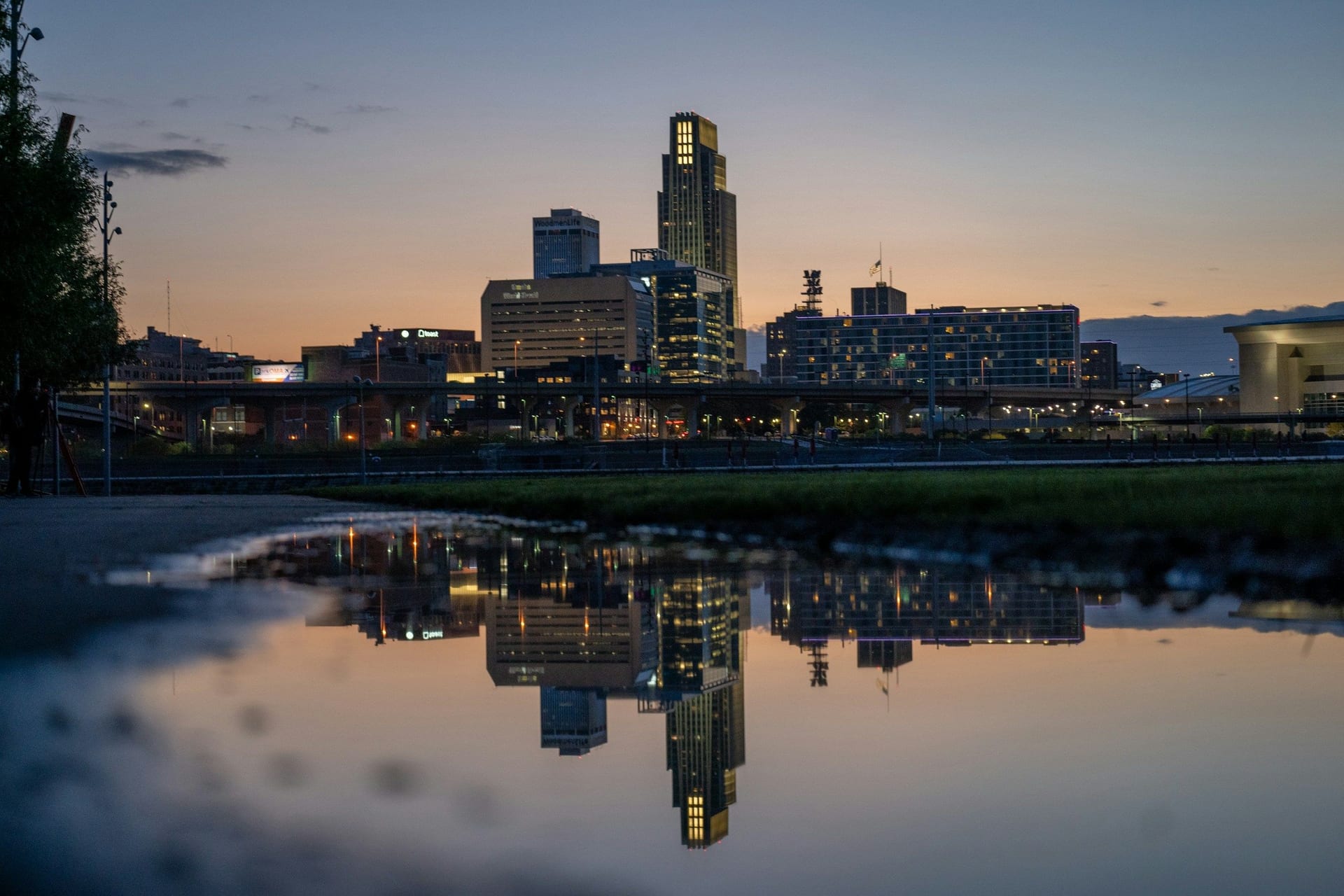 Downtown Omaha skyline at dusk reflected in a puddle, Nebraska