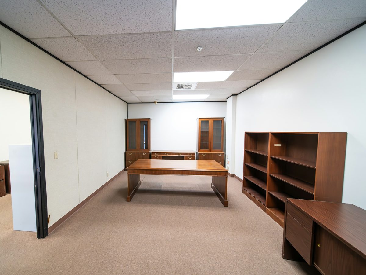 Vacated office suite with a desk and shelving left behind